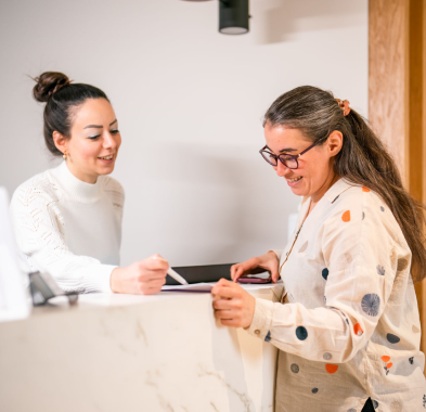 Receptionist assisting woman at counter