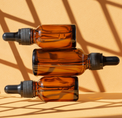 Amber dropper bottles on orange background